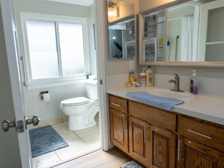 Accessible bathroom with wood cabinetry, white countertop, and natural light