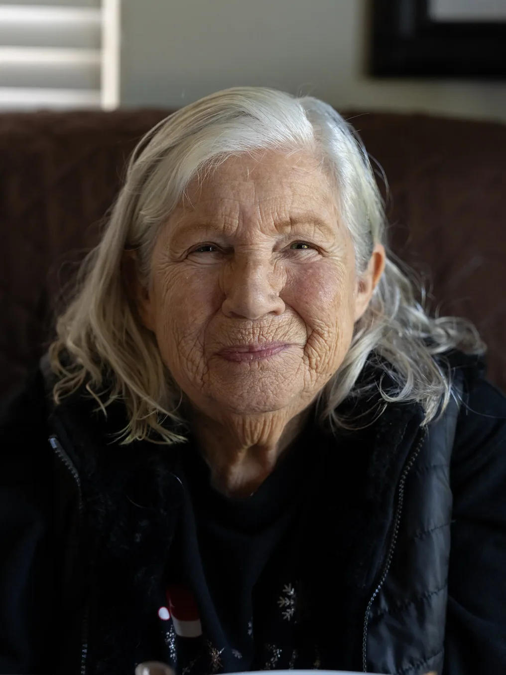 Senior woman resident smiling warmly in a comfortable home setting